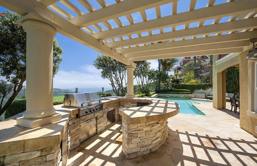 mediterranean style patio with outdoor kitchen and covered pergola.jpg